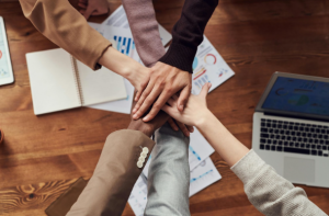  Diverse team stacking hands in unity.