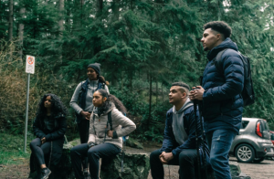  Team of hikers resting in forest.