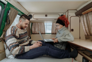 Couple working remotely in camper van.